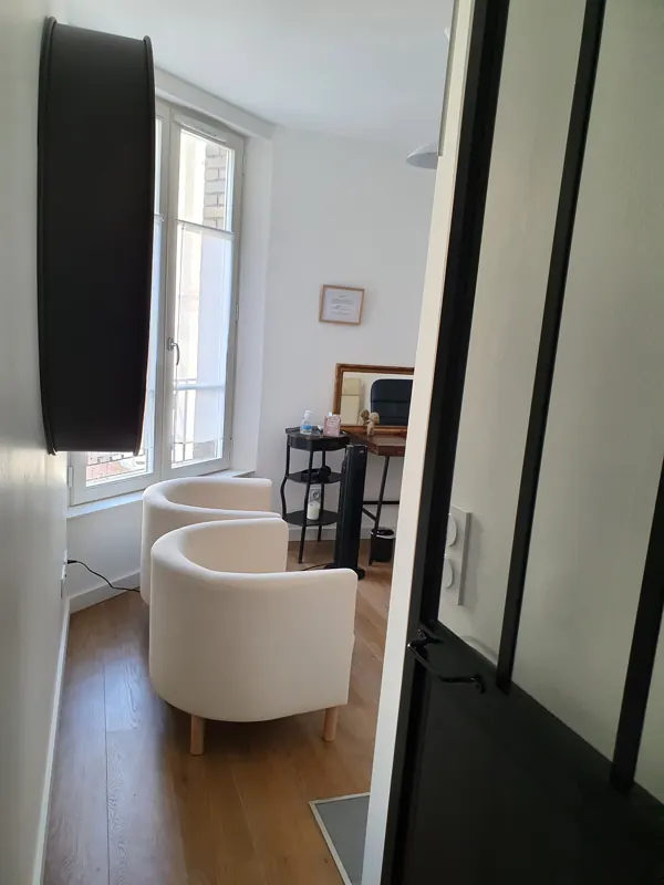 Salle de consultation : deux fauteuils blancs près d'une fenêtre